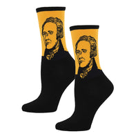 A pair of yellow women's socks with a black cuff and a print of Alexander Hamilton's face in the center.