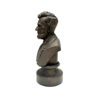 A side profile view of the bronze colored statue of the head of Abraham Lincoln up to the torso