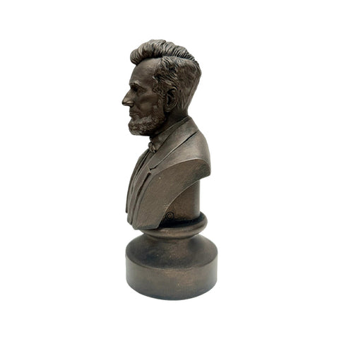 A side profile view of the bronze colored statue of the head of Abraham Lincoln up to the torso