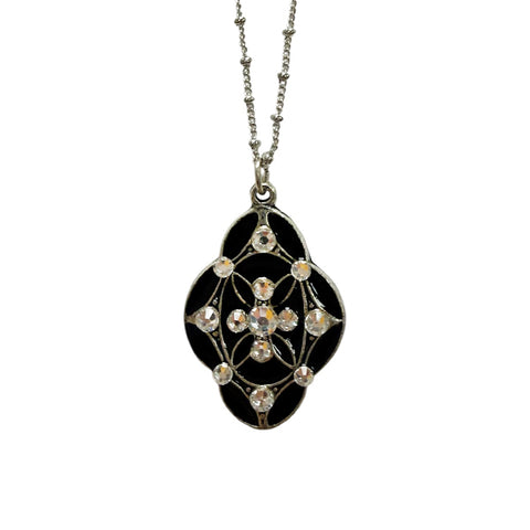 Silver pendant necklace in the same of a diamond with rounded edges with encrusted gemstones in the perimeter of the shape and a diamond group in the center of the pendant on a silver necklace