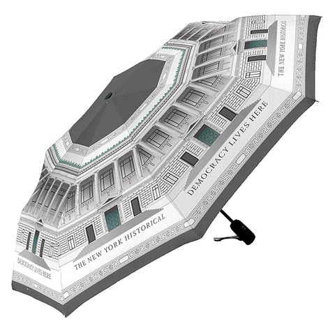 A umbrella featuring a grey-toned wrapped design of the The New York Historical Facade  with the text 