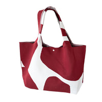 A tote bag with red and white abstract patterns