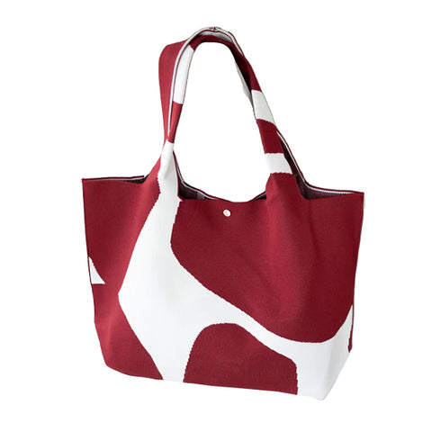 A tote bag with red and white abstract patterns