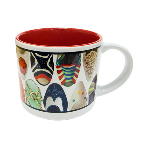 A side view of a white ceramic mug featuring a variety of illustrated designs of the front of shoes and heels with a red interior
