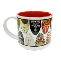 A side view of a white ceramic mug featuring a variety of illustrated designs of the front of shoes and heels with a red interior.