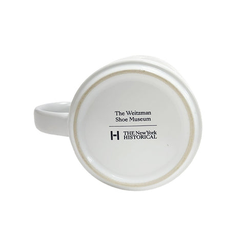 The bottom view of a white ceramic mug featuring the text 