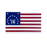 A rectangle-shaped sticker of a American revolutionary war flag in red, white and blue with thirteen stars and the number seventy six