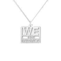 A silver pendant with the text 