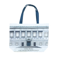 A canvas tote bag featuring an illustration of The New York Historical Building with the text 'THE NEW YORK HISTORICAL' and 'TANG WING FOR AMERICAN DEMOCRACY'with teal handles.