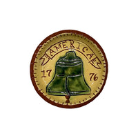 miniature red terracotta plate with a bell in the center and the text 