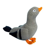 A knitted toy pigeon in gray, black, and orange.