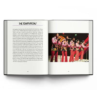 An open hardcover book showing two printed pages side by side on a white background. The left page has a black header reading 'THE TEMPTATIONS' with a block of text below, and the right page contains a color photograph of a musical group performing in red outfits.