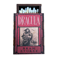 A miniature wooden matchbox featuring the original classic cover of Bram Stoker's book 'Dracula', filled with matches, shown against a plain white background.