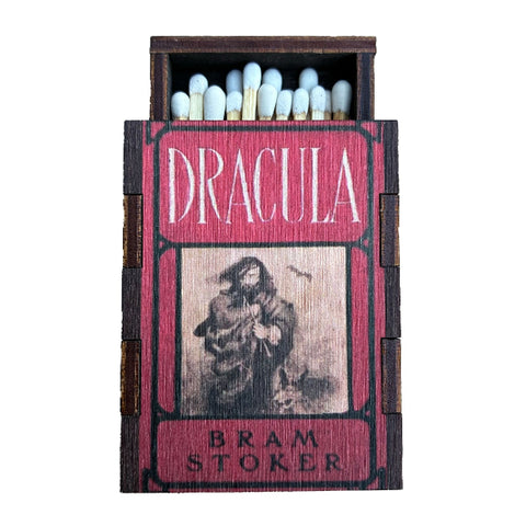 A miniature wooden matchbox featuring the original classic cover of Bram Stoker's book 'Dracula', filled with matches, shown against a plain white background.
