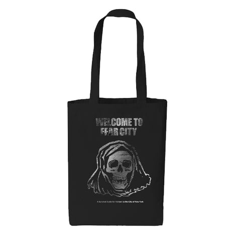 A black canvas tote featuring the text 'WELCOME TO FEAR CITY' above a distressed hooded grim reaper skull illustration, centered on a plain white background with the text "A Survival Guide for Visitors to the City of New York" at the bottom
