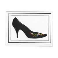 A notecard that depicts black heels with colorful floral embroidery on the front toe and heel of the shoe