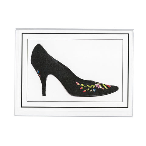 A notecard that depicts black heels with colorful floral embroidery on the front toe and heel of the shoe